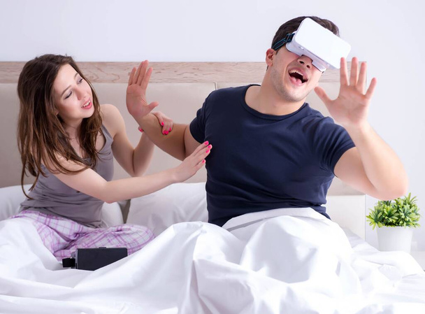 Feleség és férj virtuális valóság szemüveg az ágyban - Fotó, kép