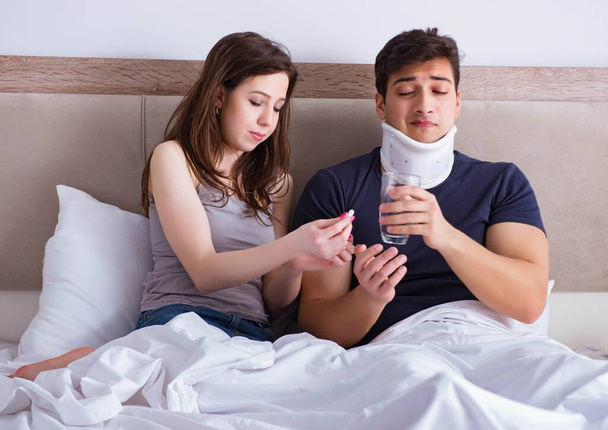 Loving wife taking care of injured husband in bed - Photo, Image