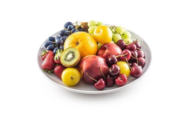 A bowl of fresh fruit on a white isolated background. - Фото, изображение