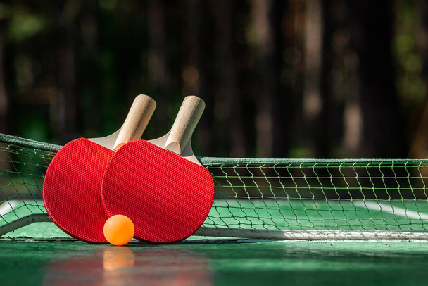 El concepto de juegos deportivos, estilo de vida saludable. Raquetas para ping pong y bolas naranjas. Espacio de copia, enfoque suave
 - Foto, Imagen