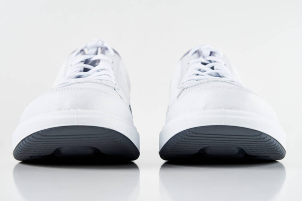 Ζευγάρι λευκά ανδρικά sneakers σε λευκό φόντο απομονωμένα. Μόδα κομψά αθλητικά παπούτσια, κοντινό πλάνο - Φωτογραφία, εικόνα