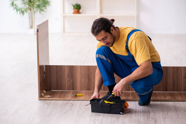Jovem carpinteiro do sexo masculino trabalhando dentro de casa - Foto, Imagem