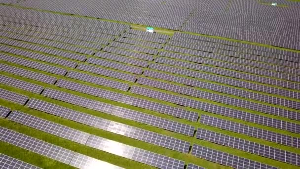 Légi felvétel a naperőműről a zöld mezőn. Elektromos panelek tiszta ökológiai energia előállítására. - Felvétel, videó