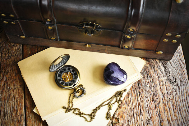 Крупный план старого деревянного багажника и старинных карманных часов и букв
. - Фото, изображение