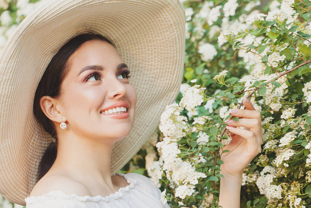 Κομψή γυναίκα σε καπέλο με καλοκαιρινά λουλούδια σε εξωτερικούς χώρους - Φωτογραφία, εικόνα