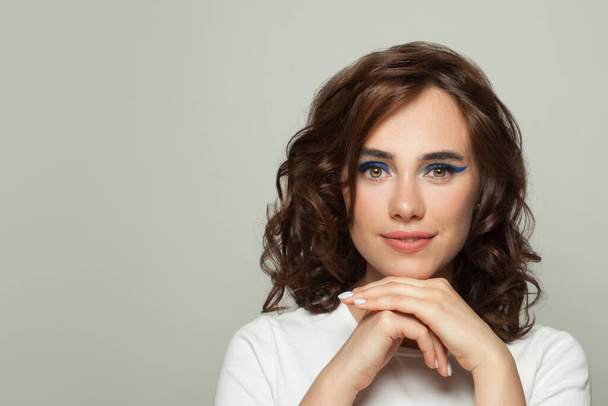 Lovely young woman with clear skin and dark curly hair portrait - 写真・画像