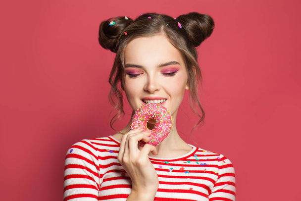 Adorável jovem mulher comendo donut
 - Foto, Imagem