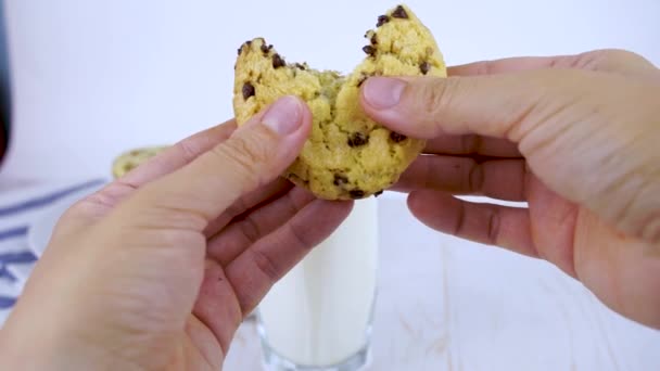 eat fresh baked classic chocolate chip cookies with nuts on a plate, glass of milk, cookie for breakfast - Footage, Video