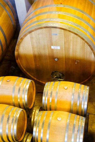 Wine barrels stacked in the cellar of the winery. - Photo, Image