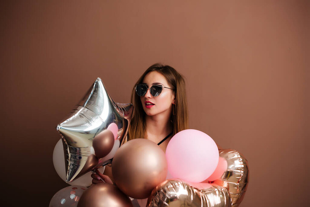 Studio portrait of a young woman with a balloon in a star heart. Close up, isolated background, copy space. - Photo, Image