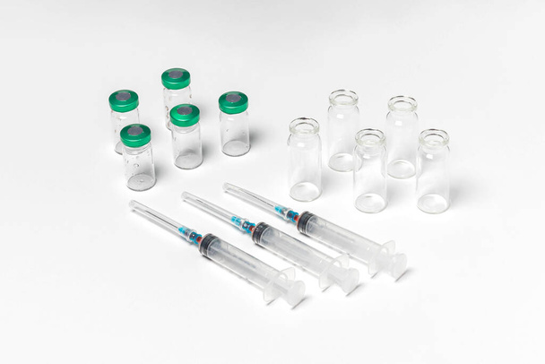 Injekční lahvičky s víčkem a bez víčka, injekční stříkačky izolované na bílém pozadí. Léčba, vyléčit pozadí, horní pohled - Fotografie, Obrázek