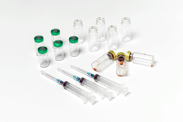 Schone en gebruikte medische injectieflacons, injectiespuiten geïsoleerd op witte achtergrond. Behandeling, genezen achtergrond, bovenaanzicht - Foto, afbeelding