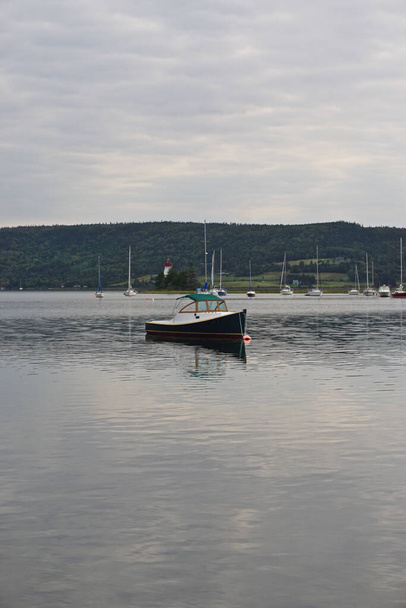 Baddeck, Nuova Scozia, Canada: Piccole barche ancorate a Bras dOr Lake sull'isola di Capo Bretone, con il faro di Kidston Island (1912) sullo sfondo. - Foto, immagini