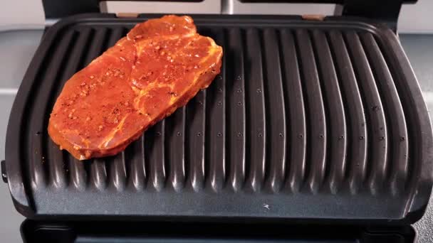 Vlees koken in een tomatenmarinade op een elektrische grill. - Video