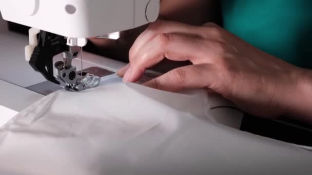 仕立て屋の伝統に従って白い布を縫う若い裁縫師の手. - 映像、動画