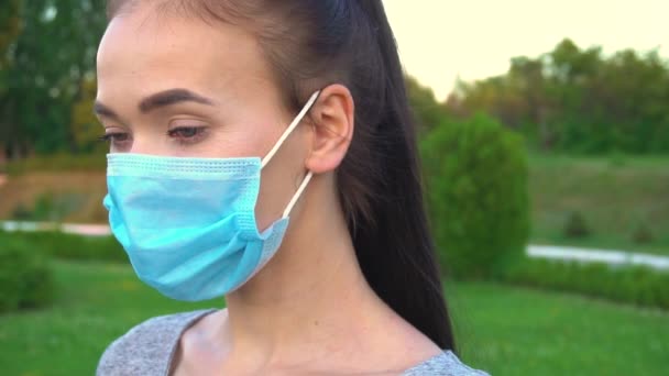 Portrait of woman weared in face medical mask, outdoor close up. - Video