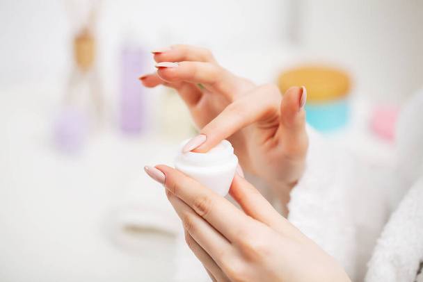 Close up of woman holding moisturizer for facial skin care - Photo, Image