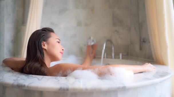 Güzel Asyalı bir kadının evde köpükle banyo yaptığı görüntüler. - Video, Çekim