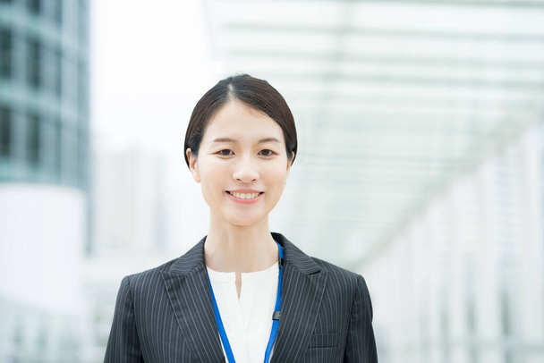 Portrait d'une jeune femme d'affaires asiatique souriante portant un costume - Photo, image