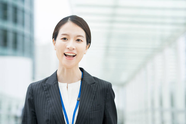 Портрет улыбающейся азиатской молодой деловой женщины в костюме
 - Фото, изображение