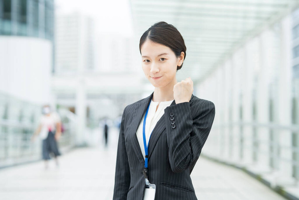 Asiatique jeune femme d'affaires dans un costume posant avec un sourire et acclamant - Photo, image