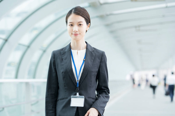 Portrait of a smiling Asian young business woman wearing a suit - Fotografie, Obrázek