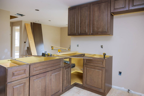 Συναρμολόγηση επίπλων προσαρμοσμένων νέων ντουλαπιών στη σύγχρονη κουζίνα - Φωτογραφία, εικόνα