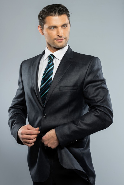 Well-dressed handsome man in black suit and tie - Фото, изображение
