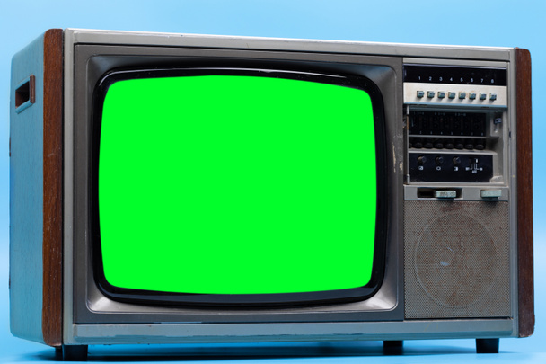 Vintage Retro Style alter Fernseher mit ausgeschnittenem Bildschirm, alter Fernseher auf blauem Hintergrund. Fernseher mit grünem Bildschirm. - Foto, Bild