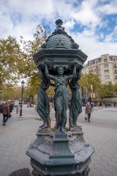 Barcelona, España - 27 de noviembre de 2019: una pequeña escultura de bronce de cuatro mujeres, ubicada en el centro de la ciudad en un passeig de gracia - Foto, Imagen