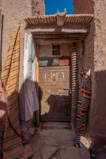 古代の木製の玄関ドアの伝統的なモロッコスタイルのデザイン。モロッコのマラケシュの古いメディナで。典型的な、古い、茶色の複雑な彫刻、ちりばめられた、モロッコの無数のドア - 写真・画像