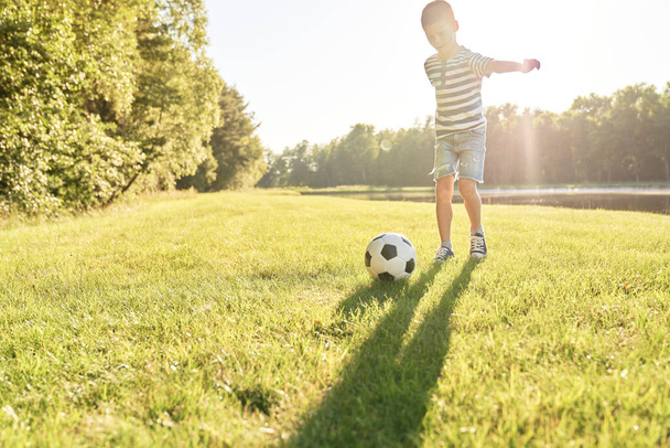                                Chłopiec zdobywa bramkę w piłce nożnej. - Zdjęcie, obraz