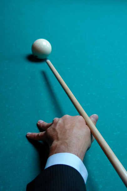 mão masculina com um taco de bilhar, bola de bilhar em uma mesa de bilhar vista superior
 - Foto, Imagem