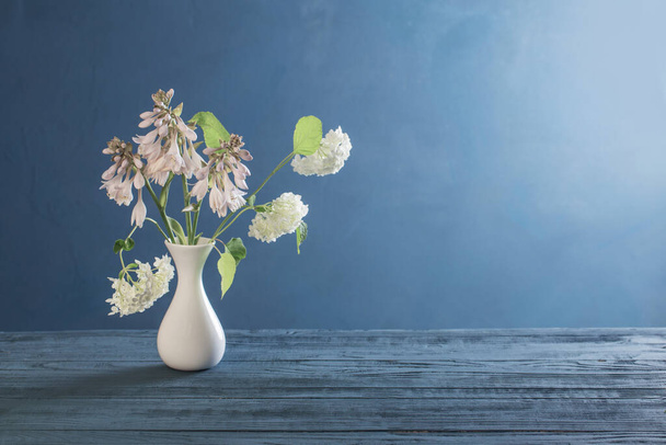 white hydrangea in vase on blue background - Foto, Imagem