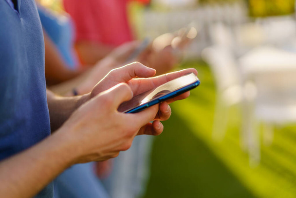 Akıllı telefon ve sosyal medya kavramını kullanan bir grup insan. Eline odaklan. Bulanık arkaplan - Fotoğraf, Görsel