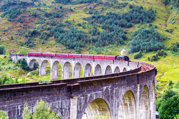 Glenfinnan Railway Viaduct en Escocia con el tren de vapor jacobita pasando. Reino Unido
 - Foto, Imagen