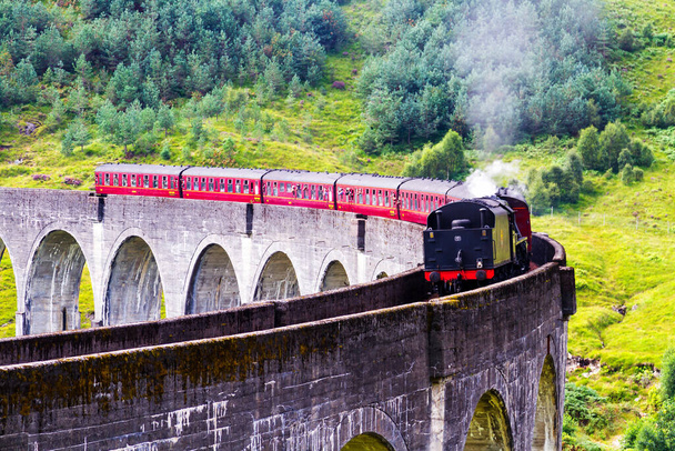 Glenfinnan Railway Viaduct in Schotland met de Jacobitische stoomtrein die oversteekt. Verenigd Koninkrijk - Foto, afbeelding