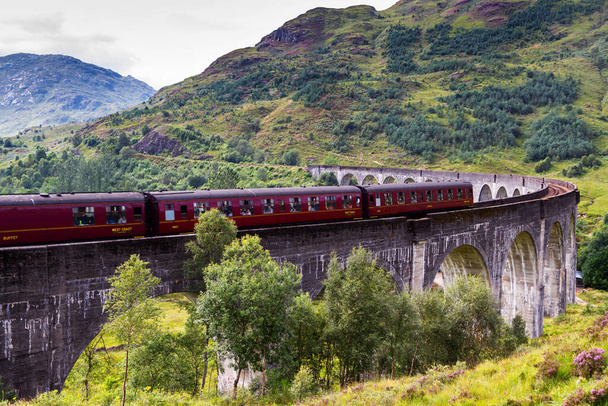 GLENFINNAN, SCOTLAND - AUGUST 20, 2016: Glenfinnan Railway Viaduct в Шотландії з паровим поїздом якобітів, що проходить в Сполученому Королівстві - Фото, зображення