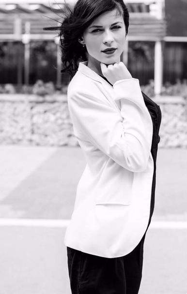 Business woman after work near her office. Stylish dressed woman in black dress and white jacket at the city - Fotoğraf, Görsel