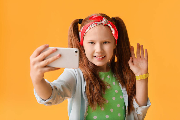 Cute redhead girl taking selfie on color background - Fotoğraf, Görsel
