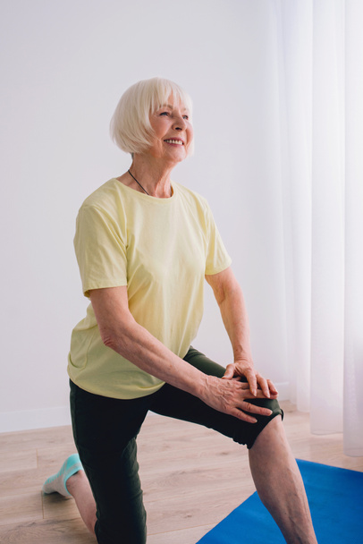senior woman doing yoga indoor. Anti age, sport, yoga concept - Fotografie, Obrázek