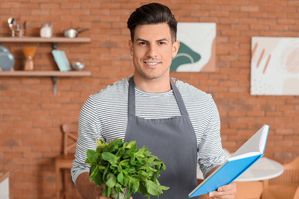 Young man with recipe book in kitchen - Foto, Bild