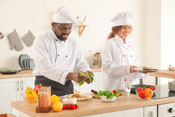 African-American chefs cooking in kitchen - Foto, afbeelding