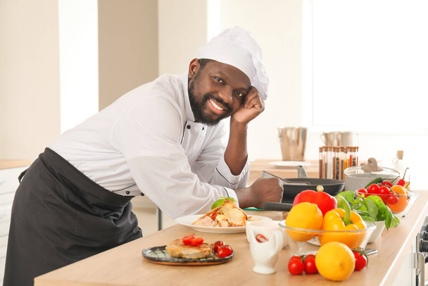 mężczyzna Afroamerykanin kucharz z smaczne danie w kuchnia - Zdjęcie, obraz