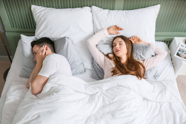 Young irritated man in bed with snoring wife - Photo, Image