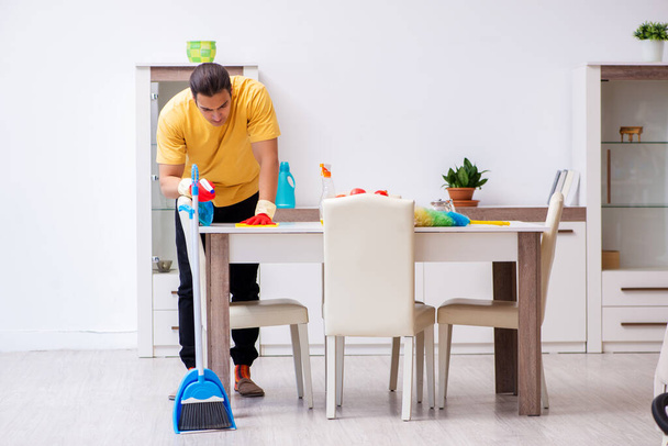 Young male contractor cleaning the house - Zdjęcie, obraz