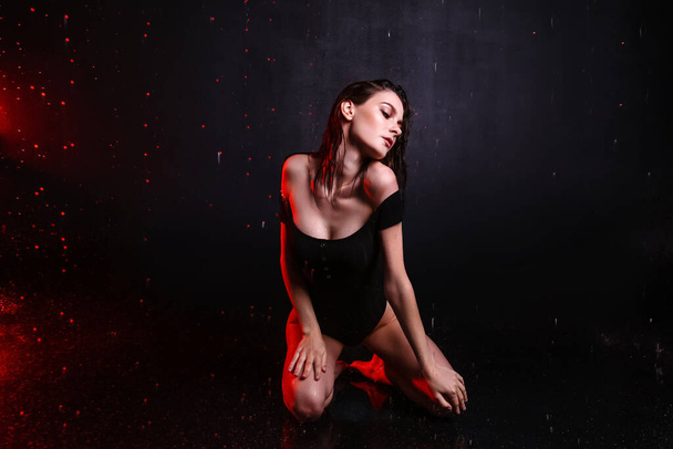 Beautiful young woman and dripping water on dark background - Foto, Bild