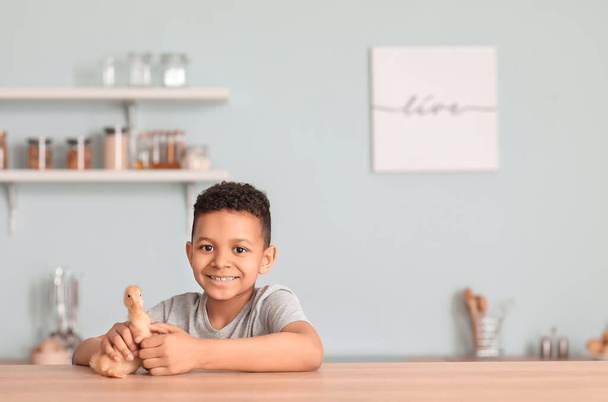 Kleine Afro-Amerikaanse jongen met schattige eendje thuis - Foto, afbeelding