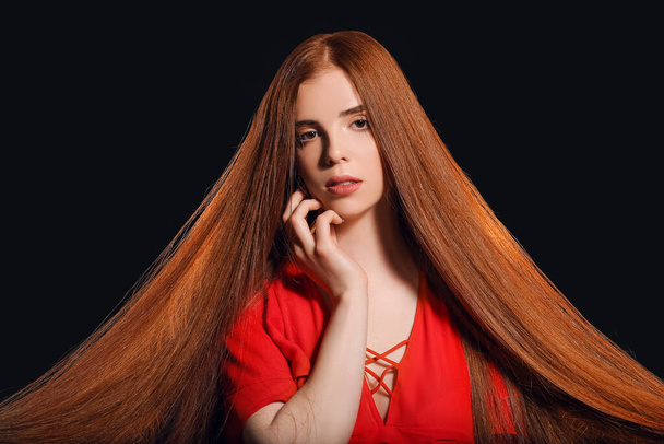 Beautiful young redhead woman on dark background - Photo, Image
