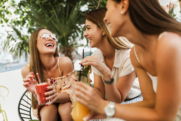 Beautiful girls drinking cocktail in cafe and having fun. - Фото, зображення